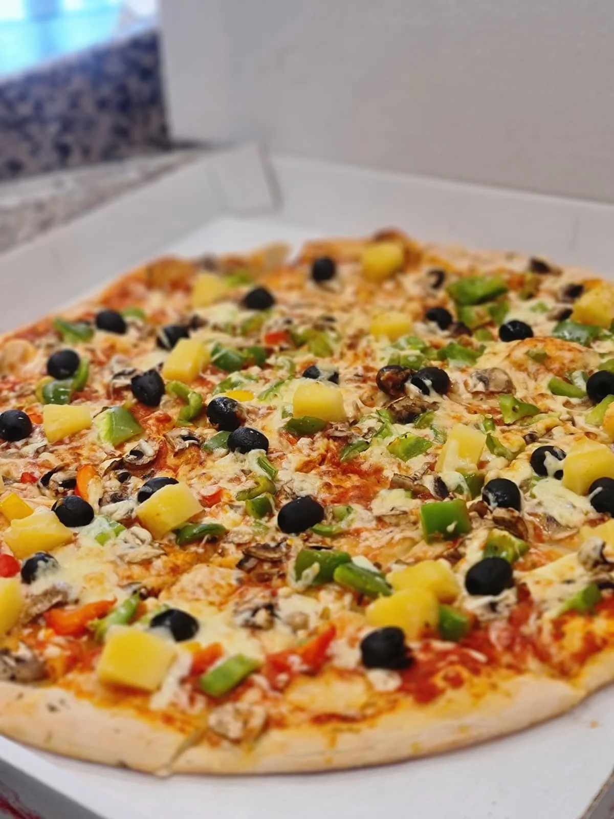 Pizza mit Ananas, Oliven, Paprika & Pilze